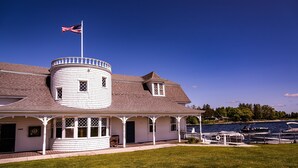 A waterfront house with a turret, a dock, and a flag.