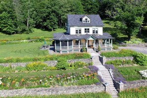 A two-story house with a porch and a garden pathway leading to the entrance. - Breezy Hill Inn (Fleischmanns)