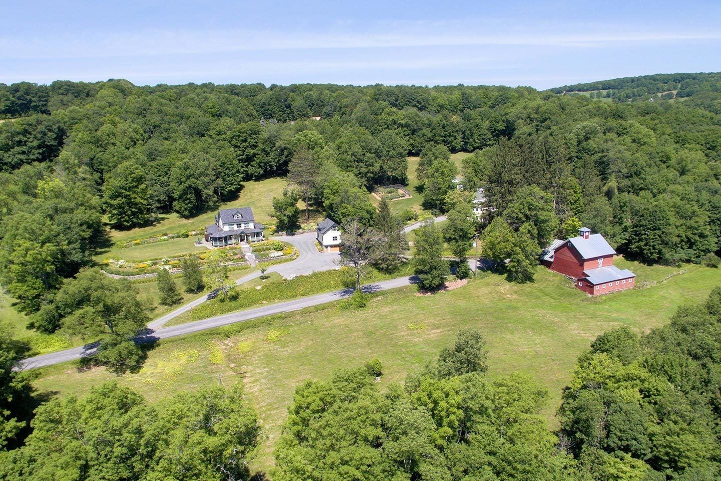 A large estate with multiple buildings, including a main house, barns, and a driveway.