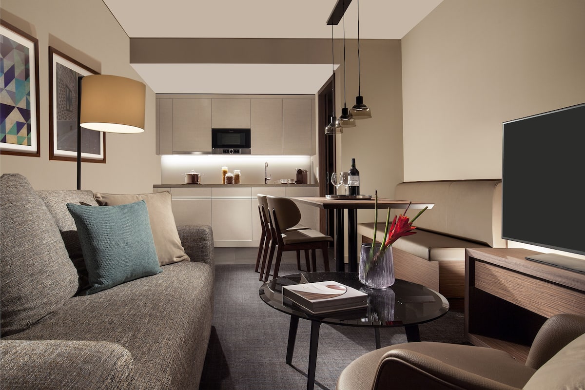 A modern living room with a sofa, a coffee table, and a flat-screen TV.