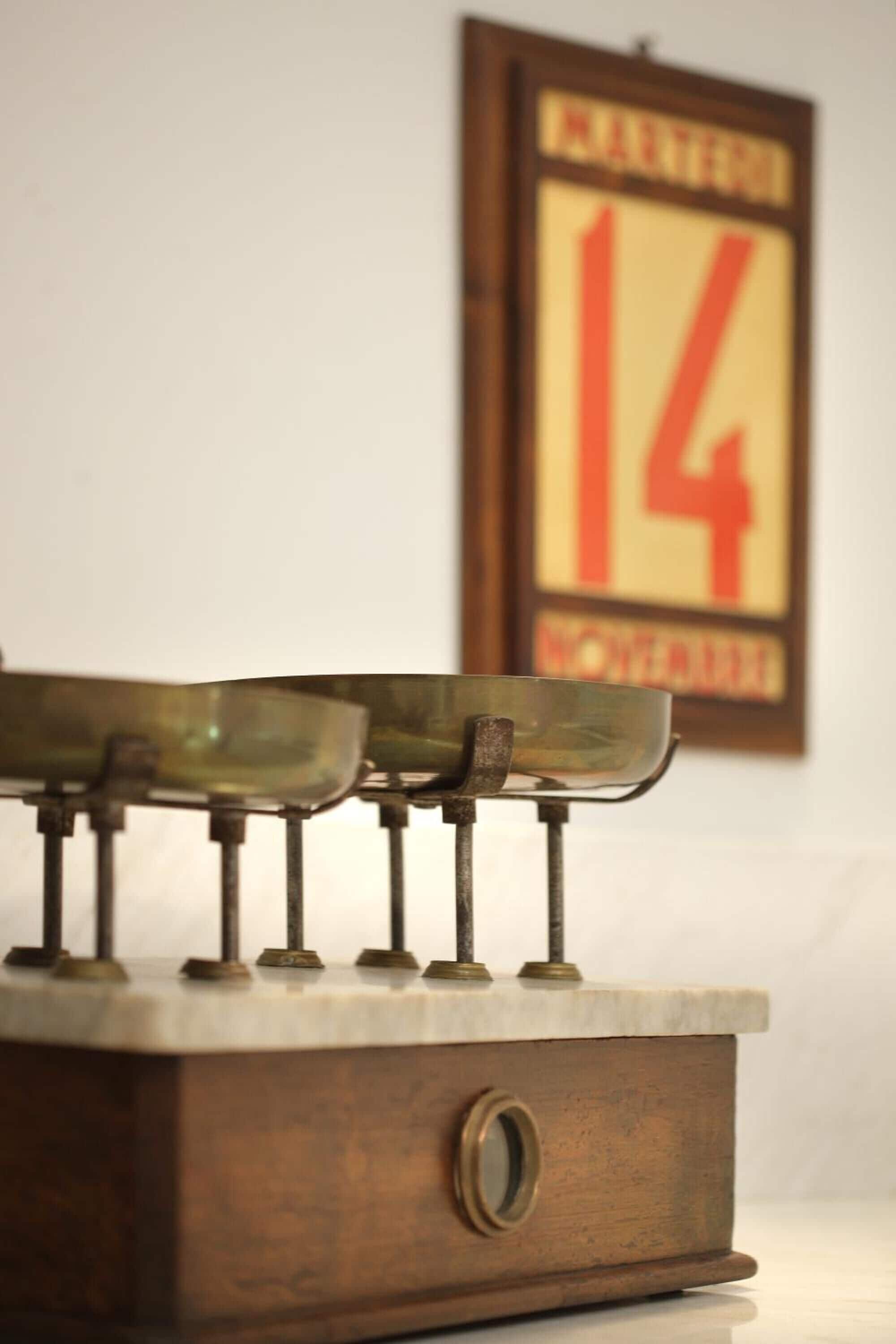 A vintage typewriter with a metal frame and a wooden base, placed on a marble surface.