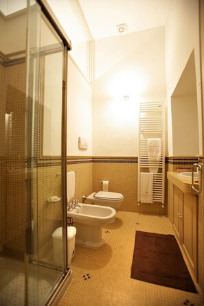 A bathroom with a glass shower enclosure, a bathtub, a toilet, and a sink. - Historical Suites VVM (Lecce)