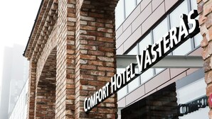 Um edifício de tijolos com uma placa que diz "COMFORT HOTEL VÄSTERAS".