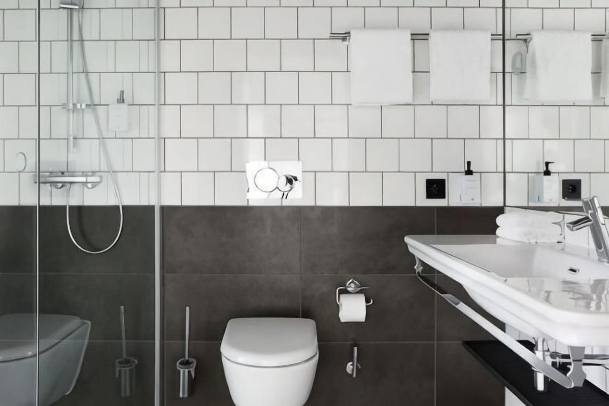 A modern bathroom with a shower, toilet, and sink.
