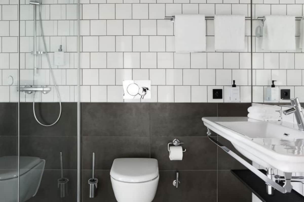 Un baño moderno con ducha, inodoro y lavamanos.