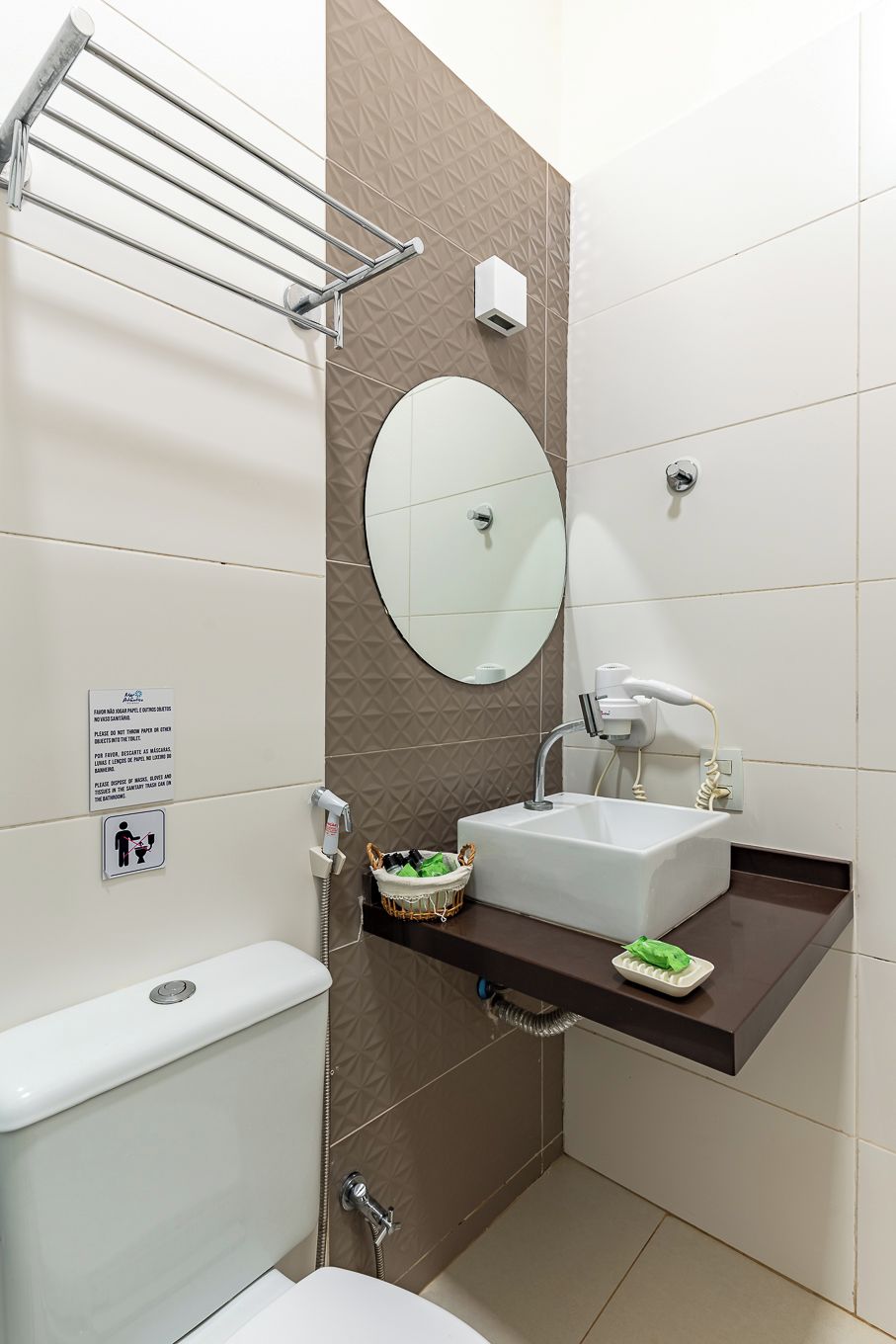 Une salle de bain moderne équipée de toilettes, d’un lavabo et d’un porte-serviettes.