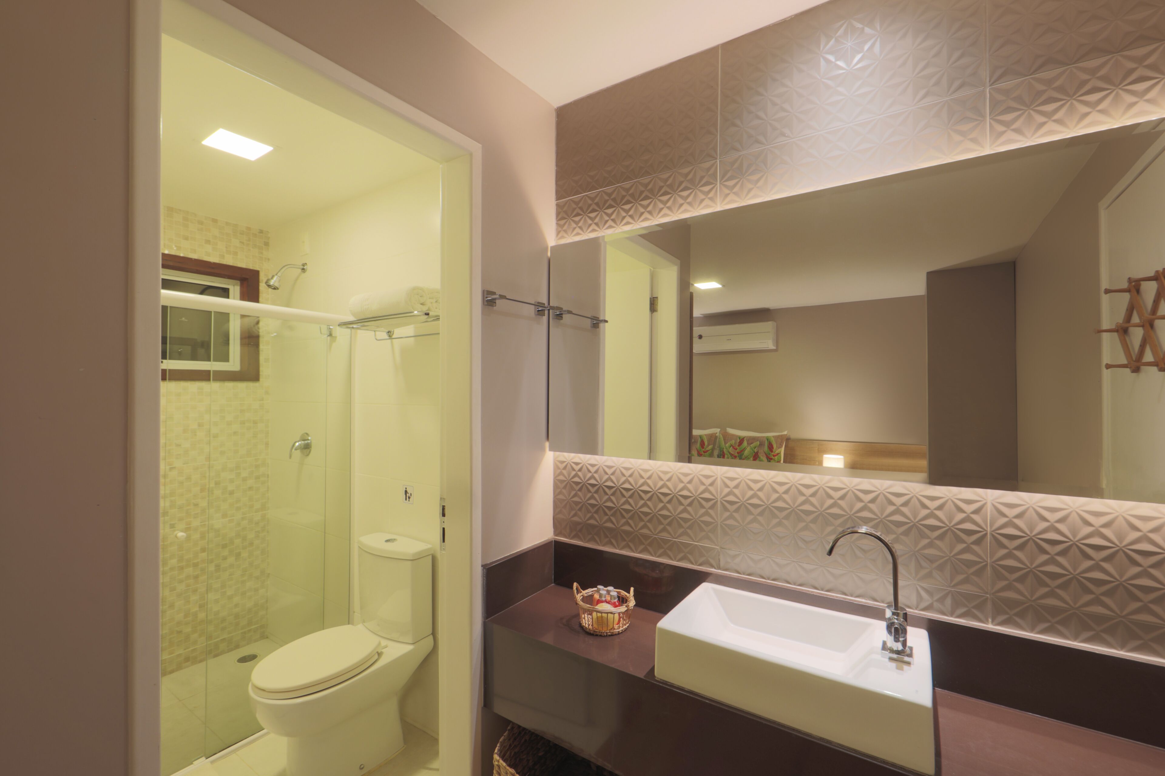 A modern bathroom with a toilet, sink, and shower.
