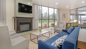 Una sala moderna con chimenea, un televisor de pantalla plana grande y un sofá.
