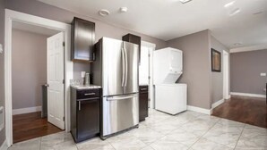 A modern kitchen with stainless steel appliances, a white refrigerator, and a tiled floor. - Elegant Tacoma condo unit in downtown B (Tacoma)