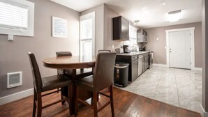 A modern kitchen with a dining area, featuring a round table and chairs, a built-in oven, and a microwave. - Elegant Tacoma condo unit in downtown B (Tacoma)