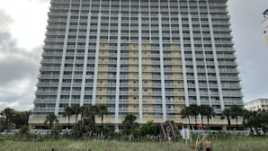 Ein Hochhaus-Hotel mit mehreren Balkonen, einer flachen Dachterrasse und einer einheitlichen Fassade.