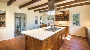 A spacious kitchen with a large island, wooden cabinets, and a modern stove. - Luxury Home, Perfect Location, Flexible Layout (Santa Fe)