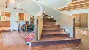 A wooden staircase with a unique curved design, leading to a second floor. - Luxury Home, Perfect Location, Flexible Layout (Santa Fe)