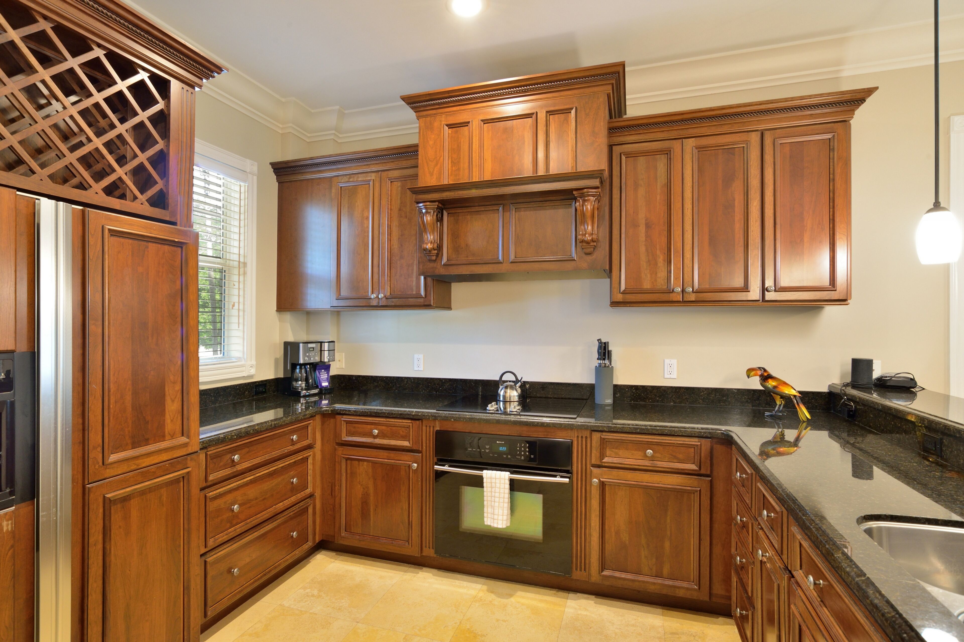 A kitchen with wooden cabinets, a stainless steel sink, and a built-in oven.