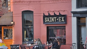 A red brick building with a sign reading "SAINT-EX". - A Cozy-kept Secret  Studio Located In The Heart Of 14/u St/logan Corridors (Washington)