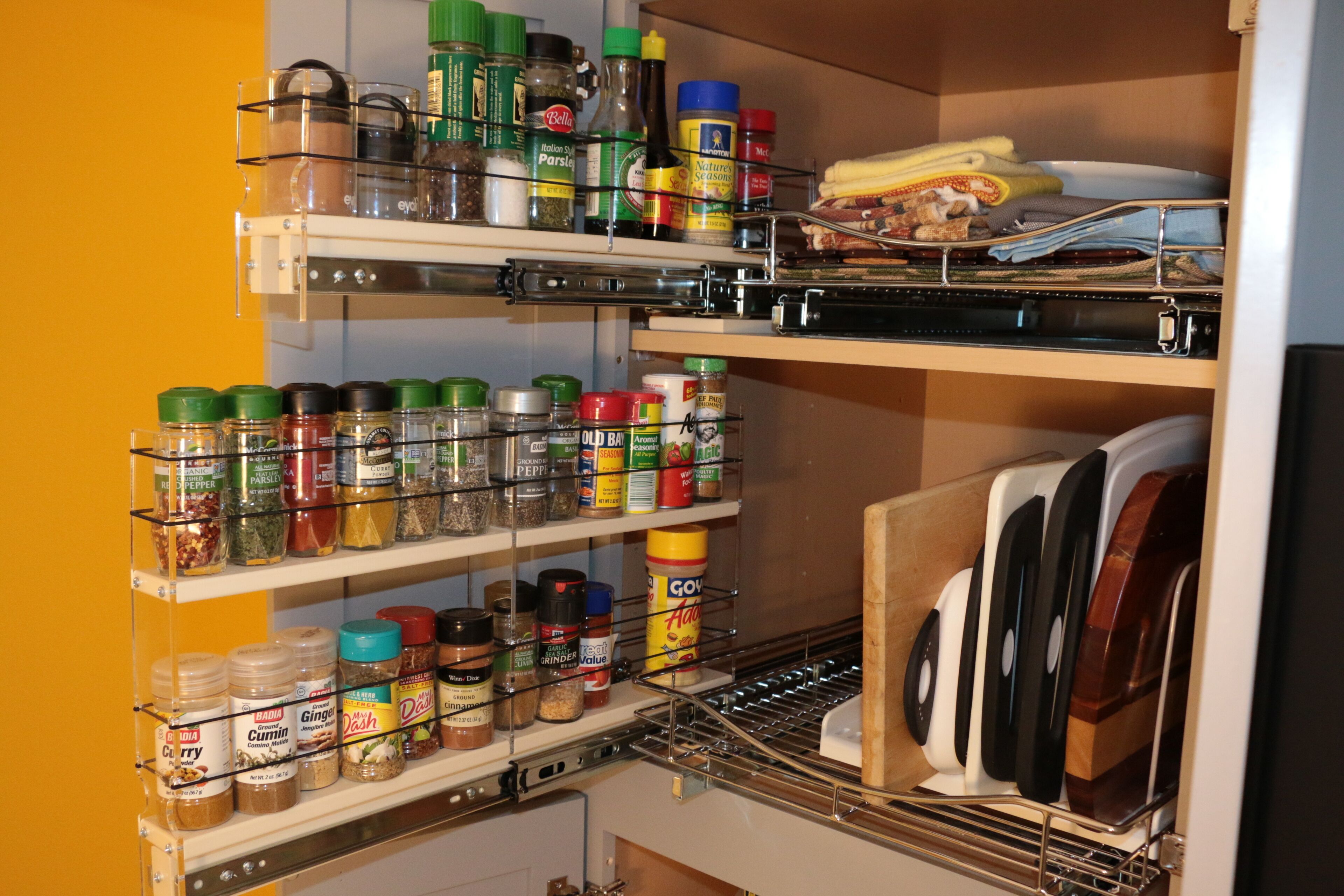 Una cocina con estantes llenos de especias, condimentos y utensilios de cocina.