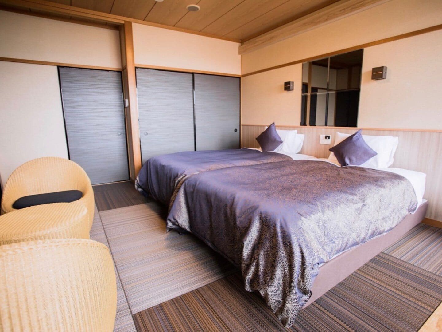 Une chambre d’hôtel avec un lit, une chaise et une porte coulissante.
