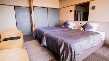 Une chambre d’hôtel avec un lit, une chaise et une porte coulissante.