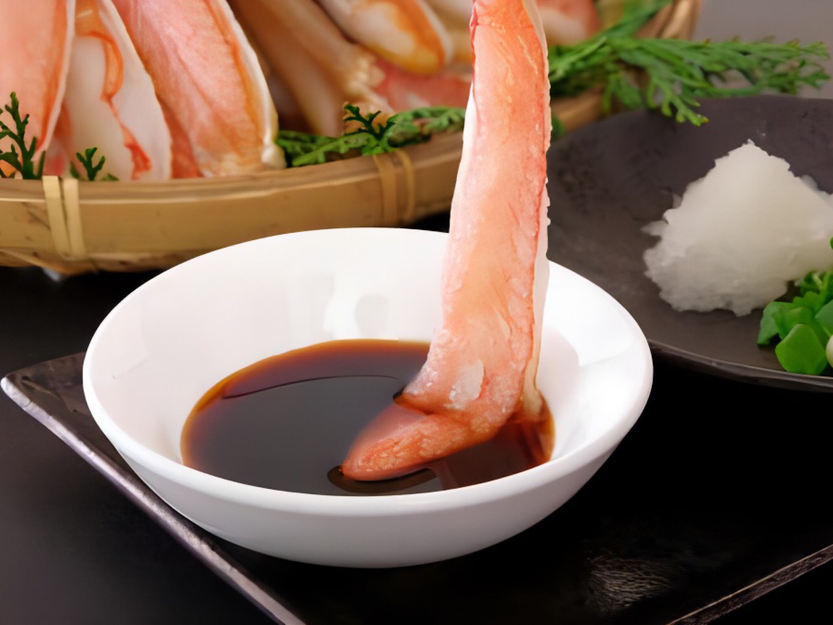Un tazón de salsa de soya con un trozo de pescado crudo.