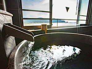 A bathtub with a view of a mountainous landscape through a window. - LiVEMAX RESORT KYOTANGO SEA FRONT (Kyotango)