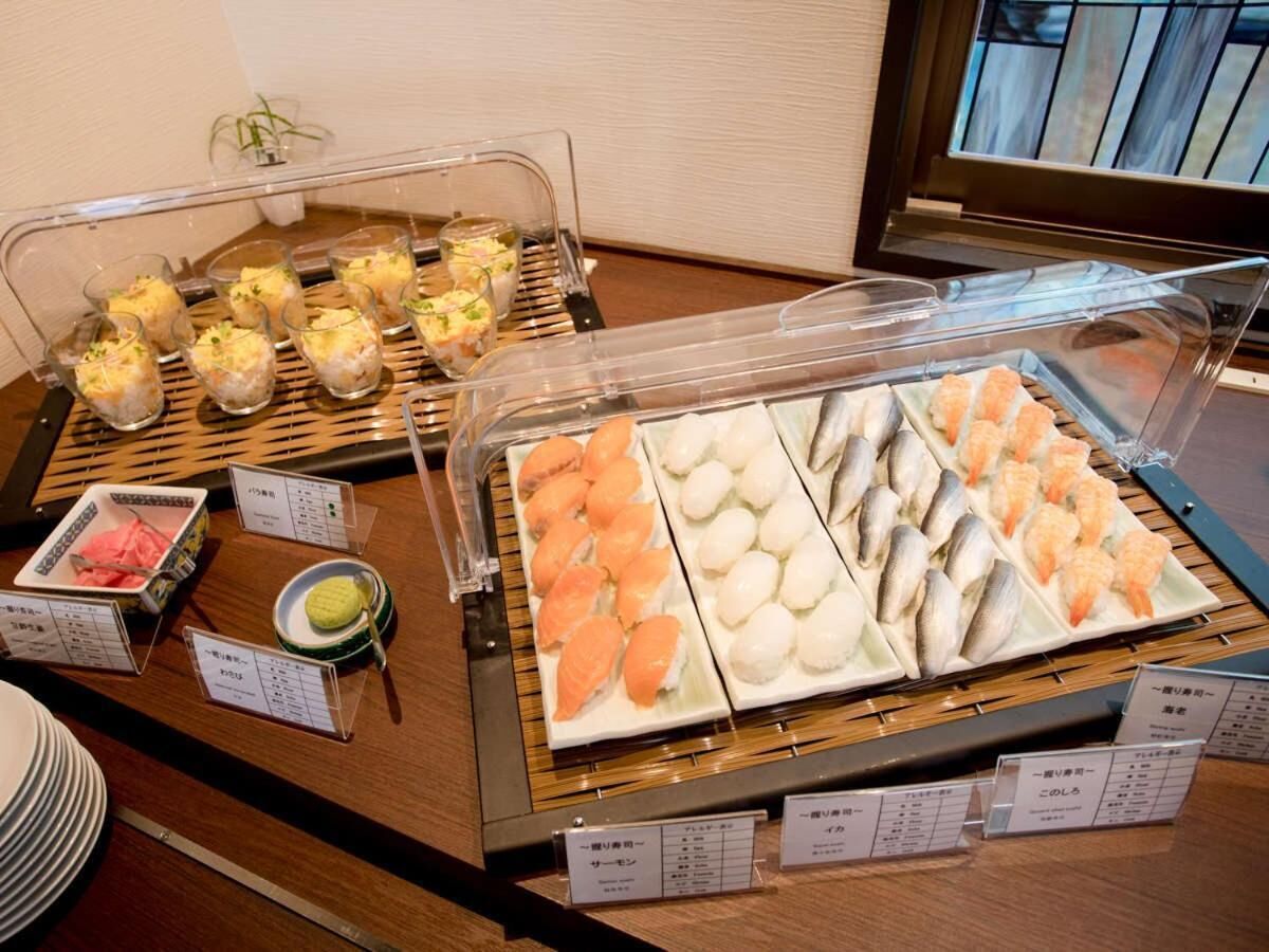 A buffet with various seafood dishes, including sushi and sashimi, displayed in clear containers.