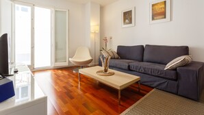Una sala de estar moderna con un sofá gris, una mesita de centro y una silla blanca.