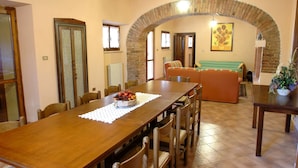 A dining area with a long wooden table, chairs, and a decorative centerpiece.