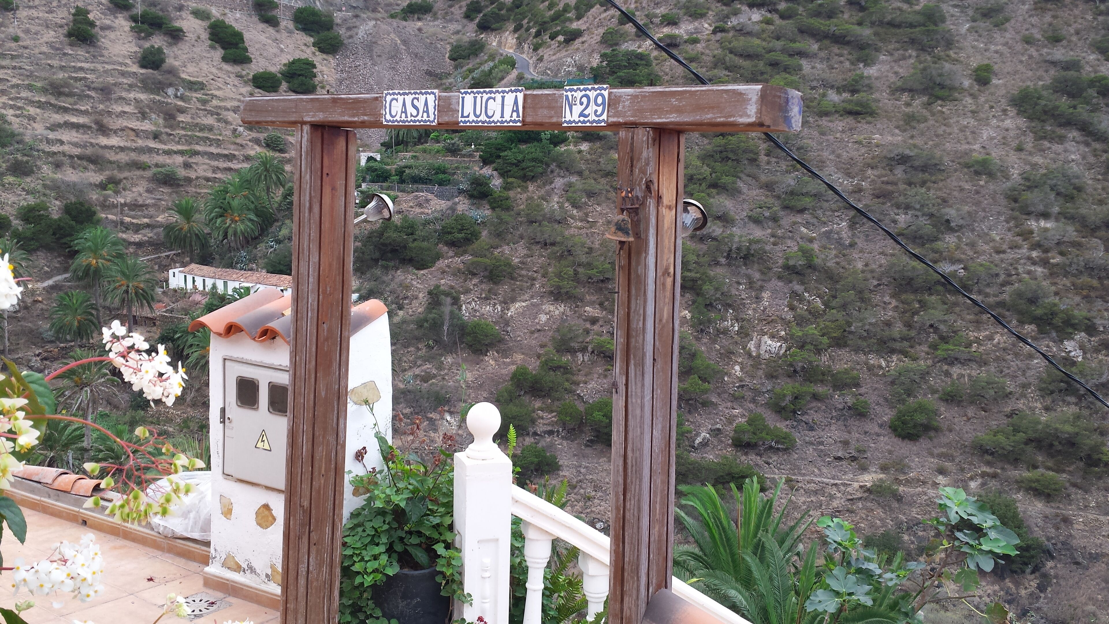 Um arco de madeira com uma placa indicando 'CASA LUCIA N29'.