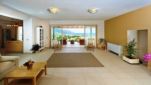 A spacious living area with a large window, a sofa, a coffee table, and a view of the outdoors.