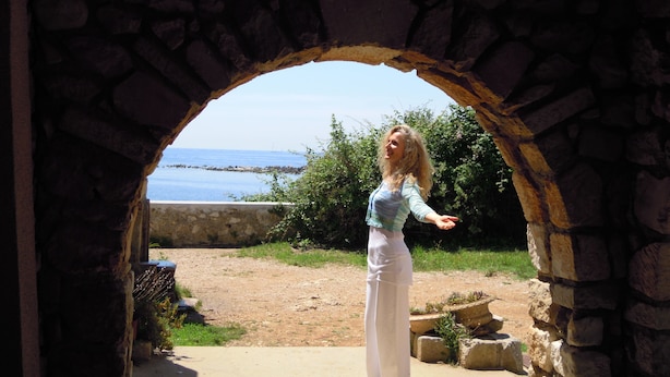 Un arco de piedra que da a vistas del mar.