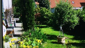Un jardin avec des plantes en pot et une pelouse.