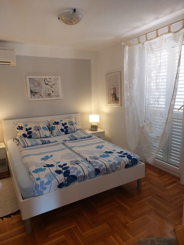 Una camera da letto con un letto, un comodino e una finestra con tende.