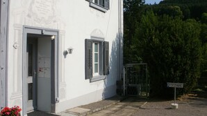 Un edificio blanco con una puerta, ventanas y un letrero que dice "PERIENWHG".