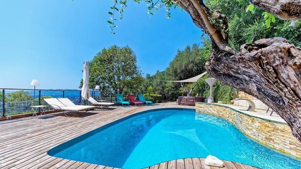 A wooden deck with a swimming pool, lounge chairs, and a tree. - Spacious air-conditioned villa, heated pool and SPA, breathtaking views. (Grasse)