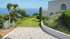 Un chemin menant à un bâtiment d’où l’on a une vue sur l’océan.
