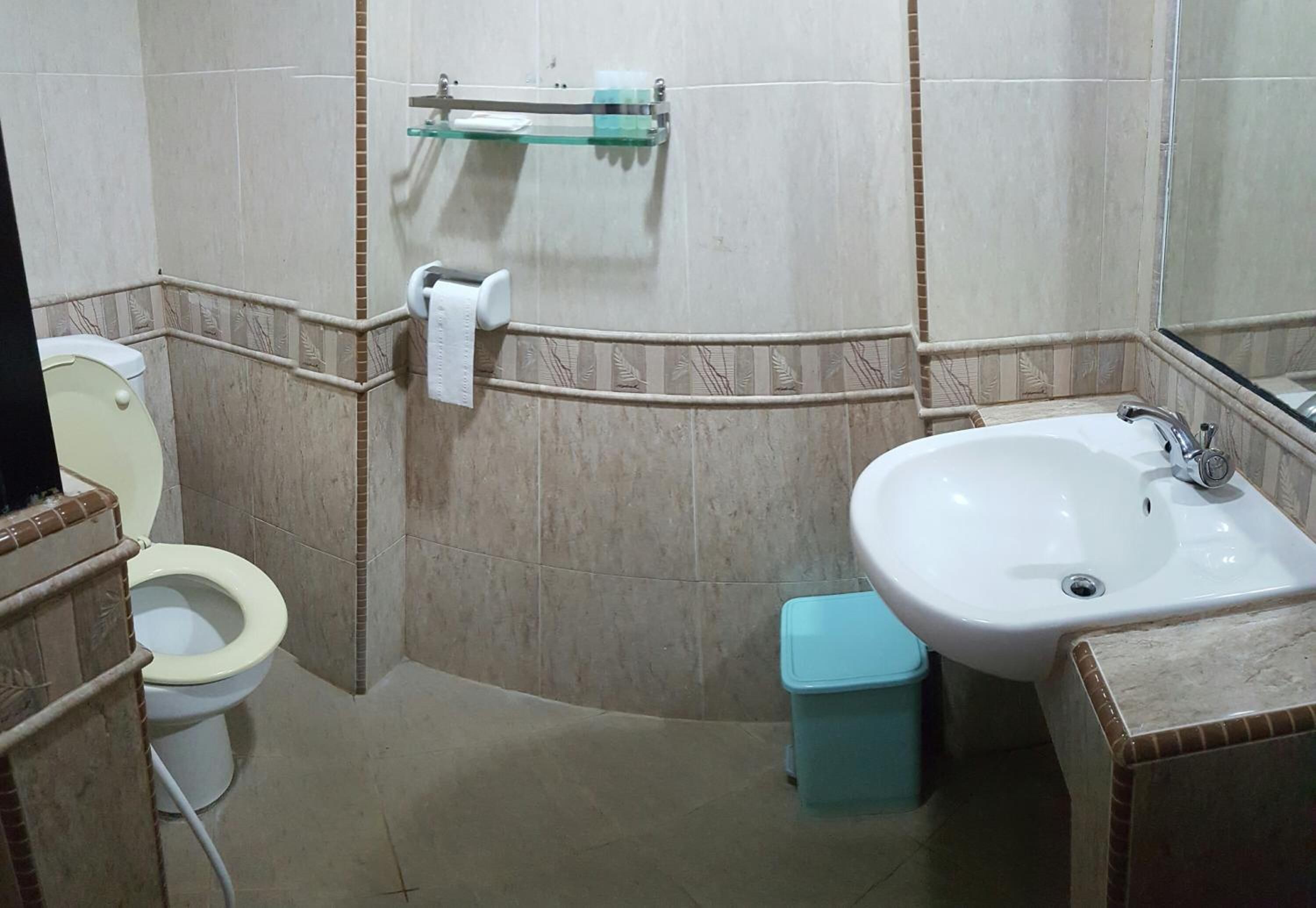Un baño con inodoro, lavamanos y espejo.