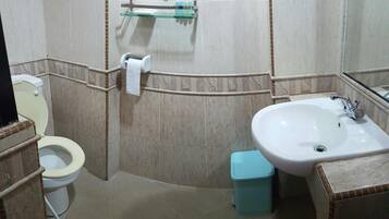 Un baño con inodoro, lavamanos y espejo.
