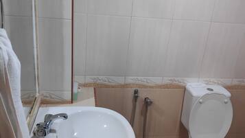 A bathroom with a sink, toilet, and shower.