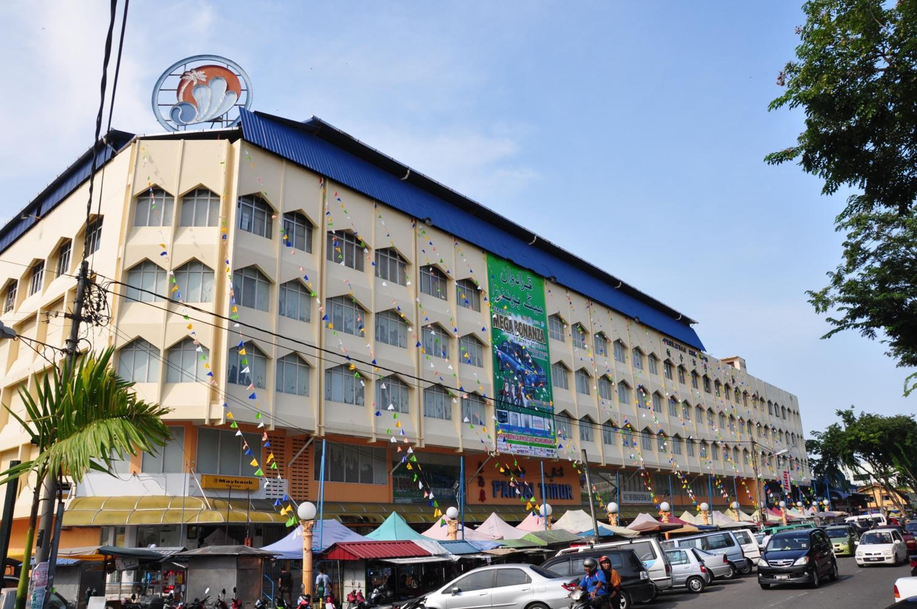 Un edificio de varios pisos con techo azul y múltiples ventanas.