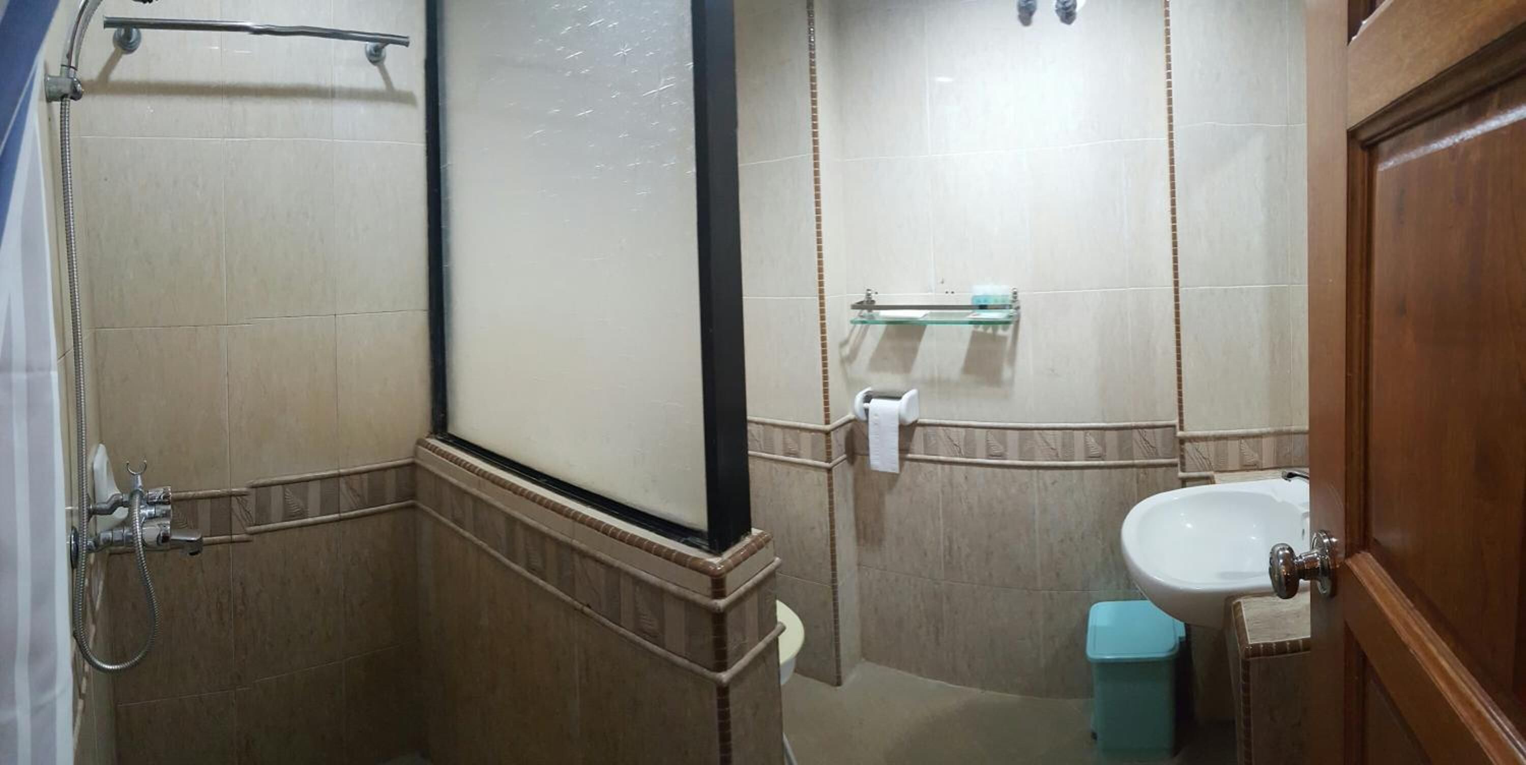 Ein Badezimmer mit Dusche, Waschbecken und Ablagefläche aus Glas.