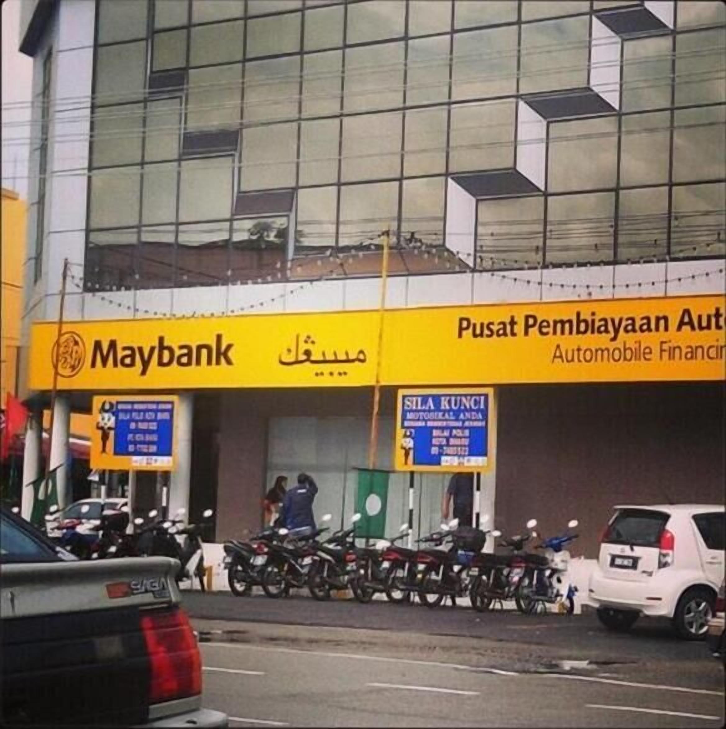 Ein Gebäude mit einem Maybank-Schild und einer Beschilderung für einen mobilen Finanzdienst.