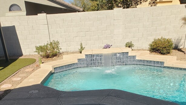 A swimming pool with a hot tub area, surrounded by a brick wall and small plants. - Beautiful Desert Vacation Home.  Heated Pool! Close to Stadium & Wigwam Resort (Litchfield Park)