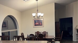 A kitchen with a central island, wooden chairs, a dining table, and a chandelier. - Beautiful Desert Vacation Home.  Heated Pool! Close to Stadium & Wigwam Resort (Litchfield Park)