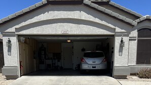 A garage with a white car parked inside, a clear sky, and a house number 12410. - Beautiful Desert Vacation Home.  Heated Pool! Close to Stadium & Wigwam Resort (Litchfield Park)