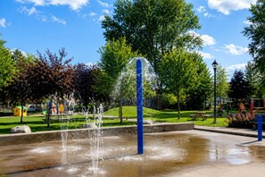 A public park with a water fountain, playground equipment, and trees. - Family Retreat – Hot Tub, Whirlpool, Free Wine, Near Old Quebec & Ski (Ville de Québec)