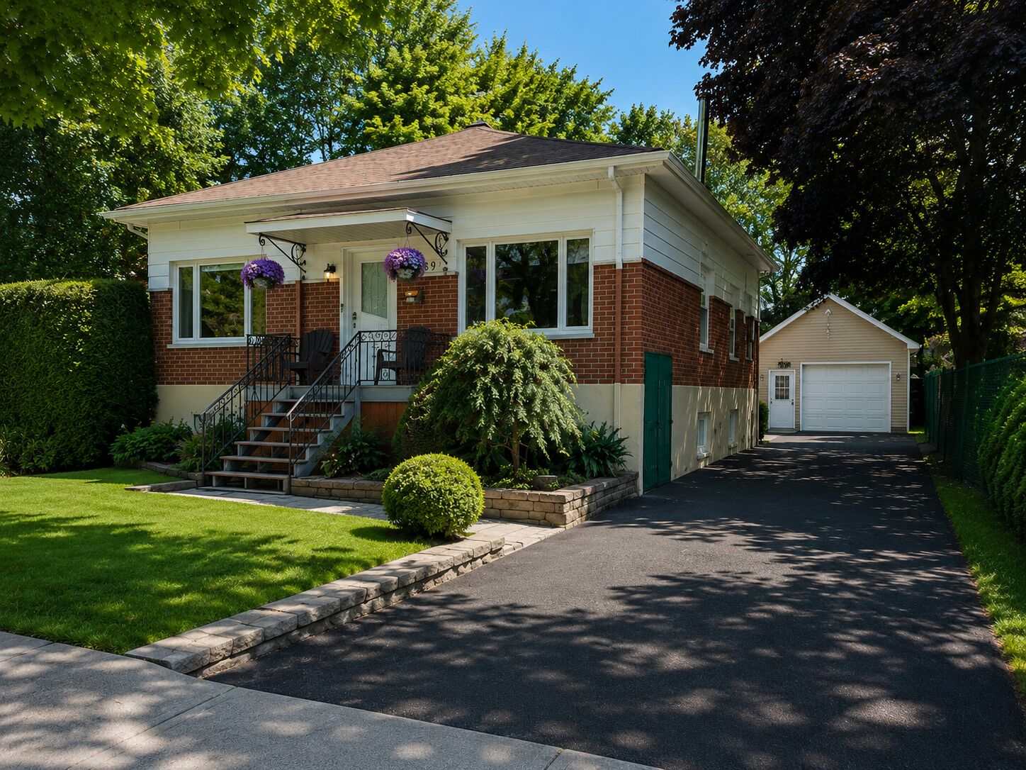 Une maison de plain-pied avec un porche à l’avant, un garage et une pelouse bien entretenue.