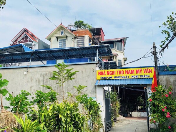 A building with a signboard and a red flag. - Nam My Van Homestay (Thai Nguyen)