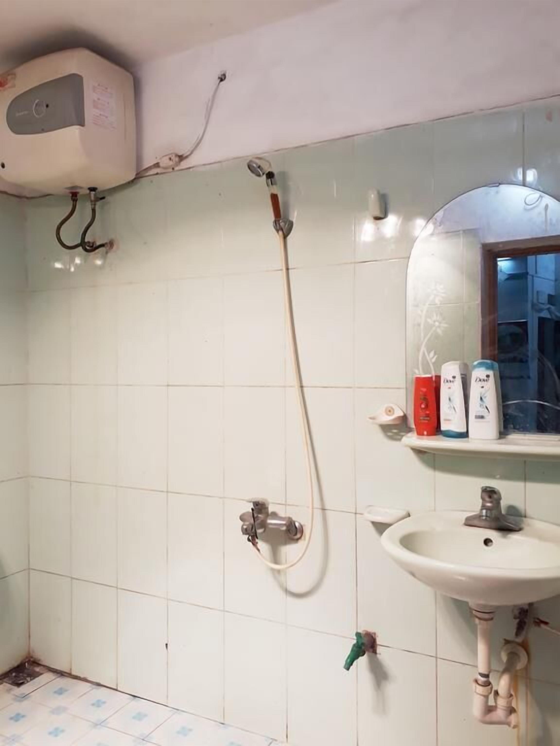 Un baño con ducha, lavamanos y espejo.