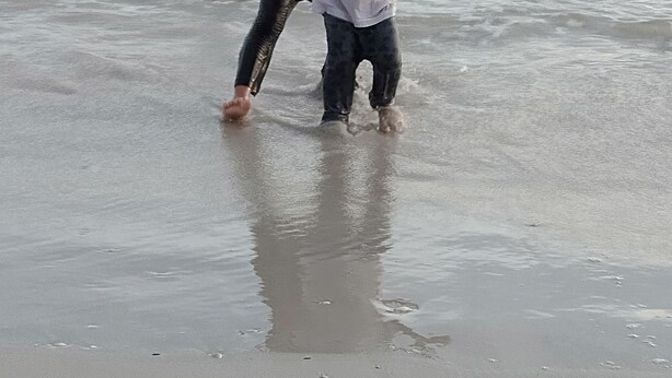 En strandscene med børn, der leger i vandet.