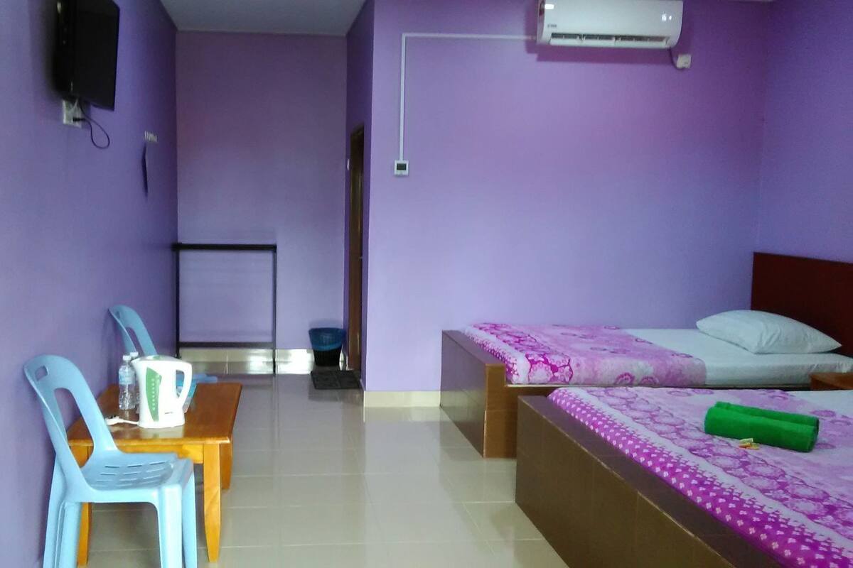 A room with a bed, a desk, a chair, and a television.